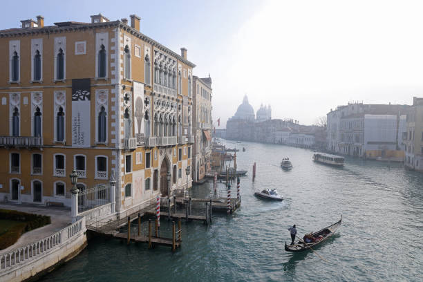 A gondola makes its way along the Grand Canal next to Palazzo Franchetti in Venice, Italy.