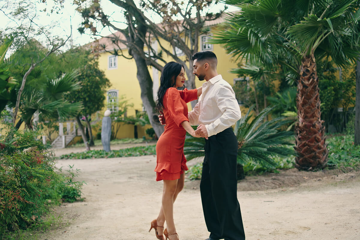 A well-dressed couple dance in an Italian village