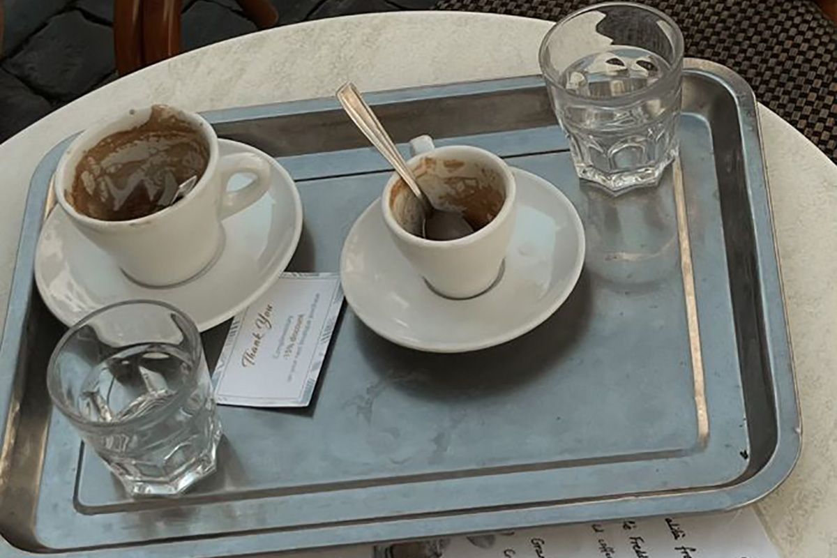 A tray holding coffee cups and water glasses